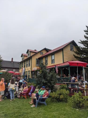 a group of people sitting in lawn chairs in front of a building at Historic 2 Cats Inn in Bar Harbor