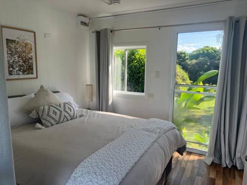 a bedroom with a bed and a large window at Hinchinbrook Riverview Retreat in Upper Stone