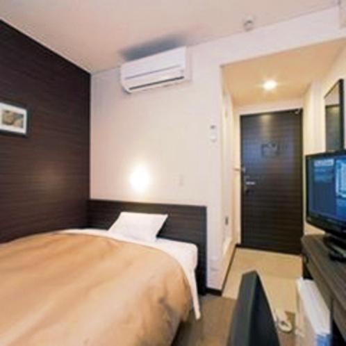 a hotel room with a bed and a television at Smile Hotel Kokura in Kitakyushu