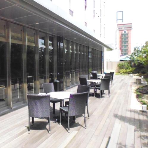 a row of tables and chairs on a building patio at Smile Hotel Kokura in Kitakyushu