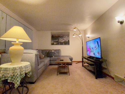 uma sala de estar com um sofá e uma televisão em Express Gateway in Stevens Point em Stevens Point