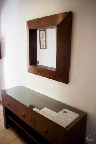a mirror on a wall above a wooden table at Alojamiento Nohal in La Iruela