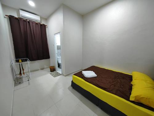 a bedroom with a bed in a white room at Homestay Mama, KB in Kota Bharu