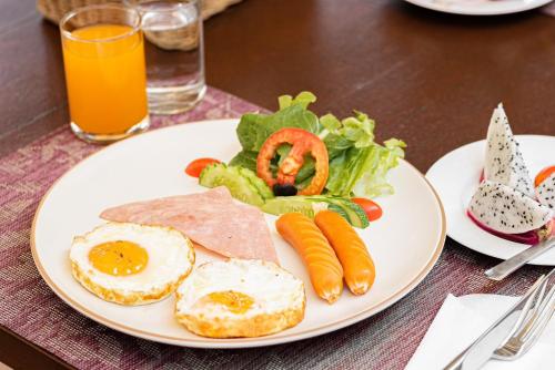 a plate of food with eggs and vegetables on a table at Khammon Lanna Resort Chiang Mai in Chiang Mai