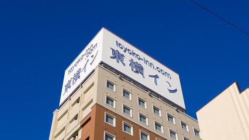 a building with a sign on the top of it at Toyoko Inn Fujisan Numazu eki Kita guchi No 2 in Numazu