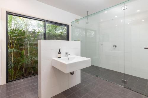 a white bathroom with a sink and a shower at At Lizzie in Elizabeth Beach