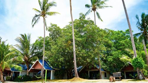 a house on the beach with palm trees at Coco Garden Resort in Thongsala