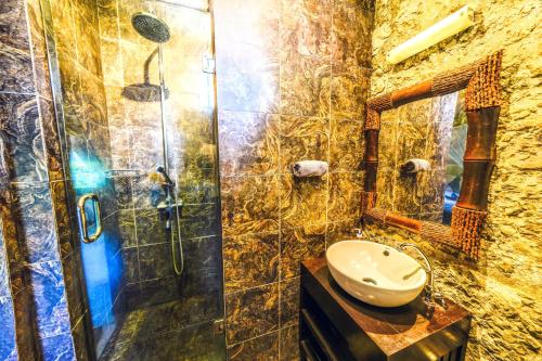 un bagno con doccia in vetro e lavandino di de CINTA Villa - KUTA - 5 bedrooms - Heart of Kuta a Kuta