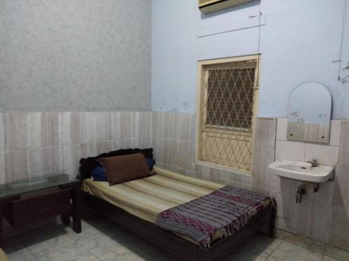 Habitación pequeña con cama y lavamanos en DK Hotel Singaraja, en Singaraja