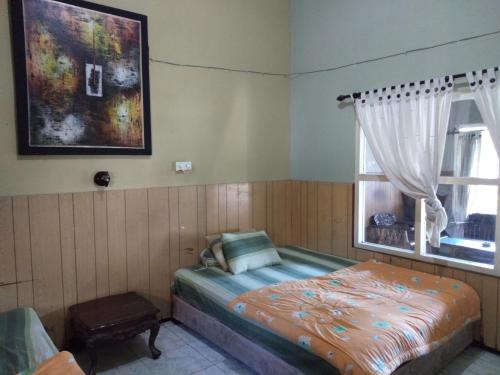 a bedroom with a bed and a window at DK Hotel Singaraja in Singaraja
