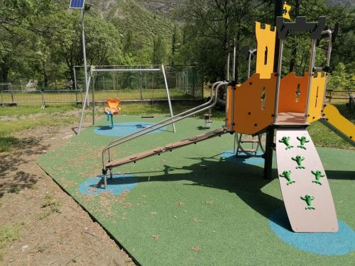 a playground with two swings and a slide at Chalet del paese Incantato comune di Moncenisio in Moncenisio