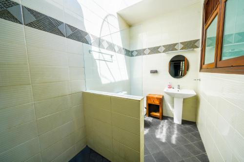 Villa SANKET - KUTA - 6 bedrooms - 6 bathrooms - Great Location في كوتا: حمام مع حوض ومرآة