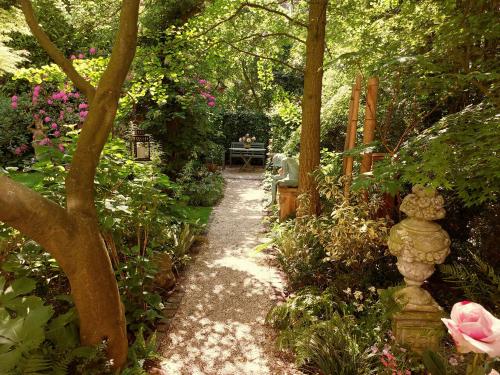 a path in a garden with flowers and trees at Gastehaus HH- Winterhude in Hamburg
