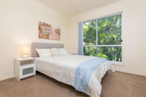 Un dormitorio con una cama y una ventana grande. en Pacific Palms, en Elizabeth Beach