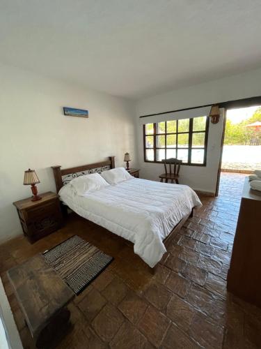 Un dormitorio con una gran cama blanca y una ventana en La Villa de San Sebastian Hotel, en Villa de Leyva