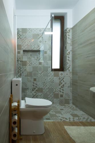 a bathroom with a toilet and a sink at Ciucea185 -Casa din Livadă in Ciucea