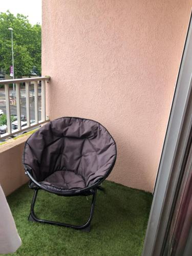 une chaise noire assise sur un balcon dans l'établissement location studio 4 pers piscine, au Cap d'Agde