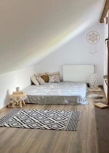 a bedroom with a bed and a rug at Ciucea185 -Casa din Livadă in Ciucea