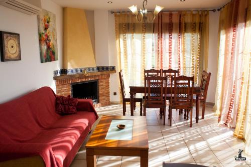 a living room with a couch and a table and chairs at Alojamiento Nohal in La Iruela