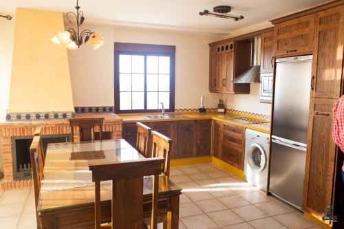 a kitchen with wooden cabinets and a stainless steel refrigerator at Alojamiento Nohal in La Iruela