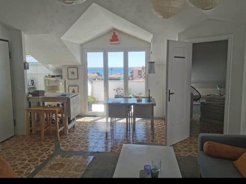 ein Wohnzimmer mit einem Tisch und eine Küche mit Aussicht in der Unterkunft The Nordic Loft - mare a 400m e parcheggio privato in Riva Ligure