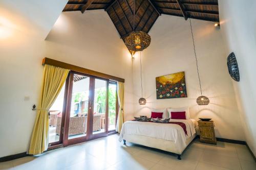 um quarto com uma cama e uma grande janela em Villa CRIS - Heart of LEGIAN 3 Bedrooms, 3 Bathrooms em Legian