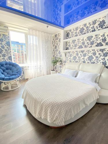 um quarto com uma grande cama branca e paredes azuis em Zoryaniy Apartments City ПРОСТОРА та затишна НОВОБУДОВА біля парку Шевченка та ЦЕНТРУ em Chernivtsi