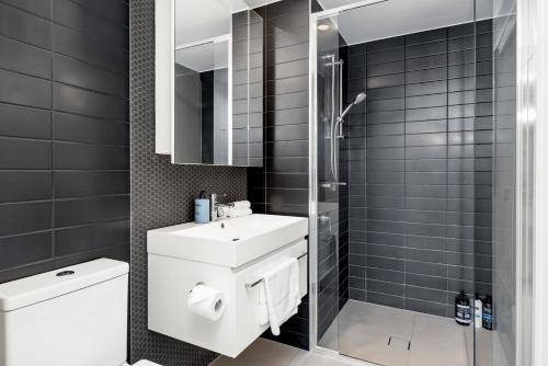 a bathroom with a sink and a shower and a toilet at Brandnew Spacious and Stunning 1bed Apartment in Brisbane
