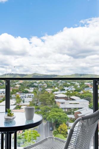 a cup of coffee sitting on a table on a balcony at Brandnew Spacious and Stunning 1bed Apartment in Brisbane