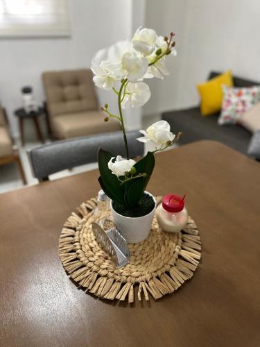 a table with a vase with white flowers on it at Hotel Bungalows Casa Blanca in Tenancingo de Degollado