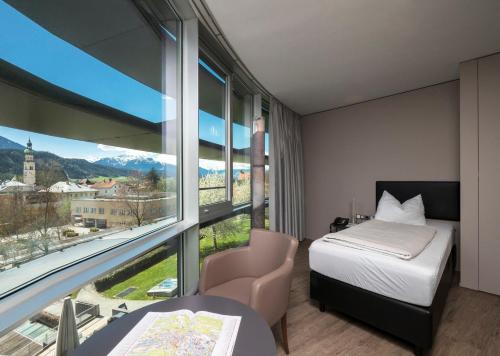 a hotel room with a bed and a large window at Parkhotel Hall in Tirol in Hall in Tirol