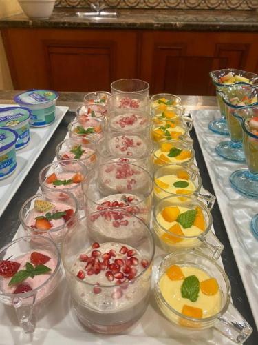 a table with many dishes of food in glasses at Holiday Inn Al Khobar by IHG in Al Khobar