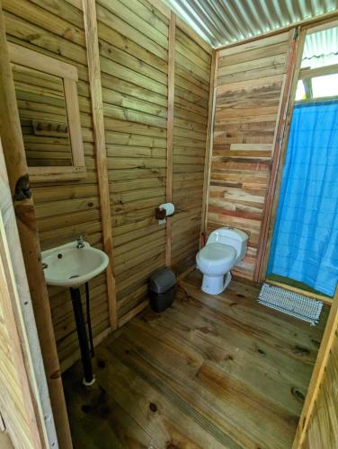 a small bathroom with a toilet and a sink at Arboura Eco Cabins in Uvita