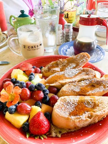 a plate of french toast and fruit on a table at Historic 2 Cats Inn in Bar Harbor