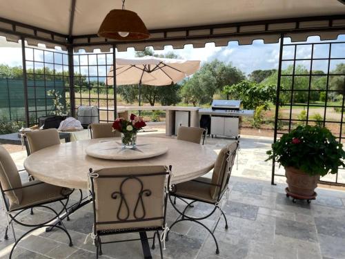 a patio with a table and chairs and a kitchen at Corte dei Mirti, camere signorili in Iglesias