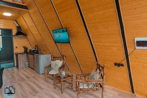 een kamer met stoelen en een televisie aan de muur bij Triangle House in Dilidzjan