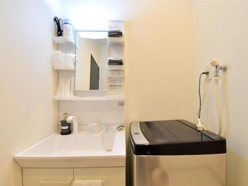 a small kitchen with a sink and a stove at The Garden Place Hiroshima - Vacation STAY 89276v in Hiroshima