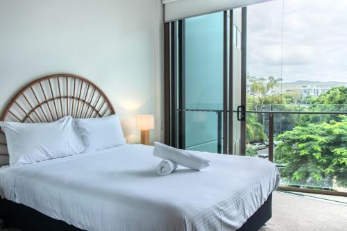 a bedroom with a white bed with a large window at Brand New Riverside Designer 2BD apartment at West End in Brisbane