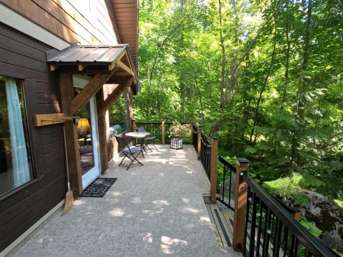 a porch of a house with a table and awning at 4 Mile Creek Cabin (Creekside) in Nelson