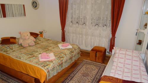 a bedroom with a teddy bear sitting on a bed at Nikiva I in Ćuprija