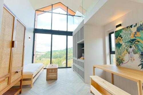 a bedroom with a bed and a large window at Talula Hill Farm Resort in Kluang