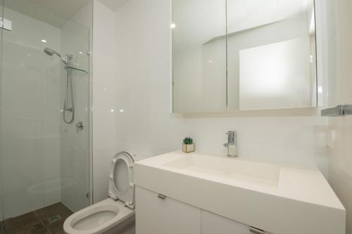 a bathroom with a sink and a toilet and a mirror at Stylish 1BD Apt with Ideal Location in Southbank in Brisbane