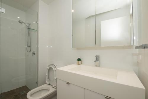 布里斯班Stylish 1BD Apt with Ideal Location in Southbank的带水槽、马桶和镜子的浴室