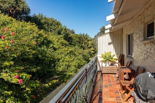 a balcony of a house with chairs and flowers at Boomerang Point Apartment in Blueys Beach