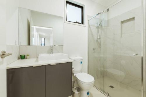 y baño con aseo, lavabo y ducha. en Spacious Modern and Cozy 3BD Townhouse at Great Location, en Gold Coast