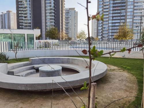 a concrete fire pit in a park with tall buildings at Exquisito Departamento a pasos de la playa en mejor sector de Reñaca y Concón in Concón