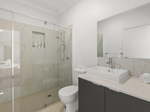 uma casa de banho com um chuveiro, um WC e um lavatório. em Newly Furnished Spacious 3BR Townhouse at GC em Gold Coast