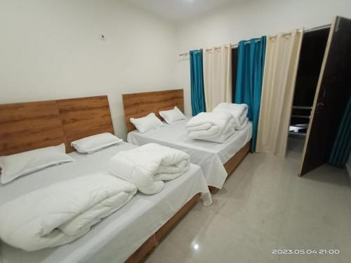 Cette chambre comprend 2 lits avec des draps et des oreillers blancs. dans l'établissement Hotel Arindam, à Phata