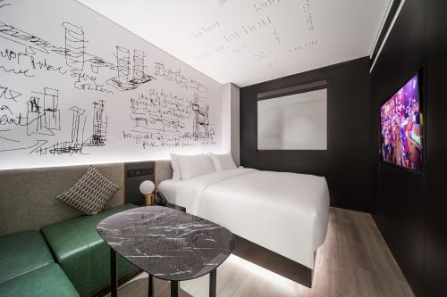 a bedroom with a bed and a table and a couch at CitiGO Hotel Shenzhen Shekou Cruise Center Seaview Near Taizi Bay K11 in Shenzhen