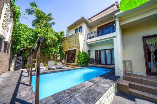 a swimming pool in front of a house at Pondok DEWI Villa - LEGIAN - 6 Bedroom Villa - Great Location in Legian